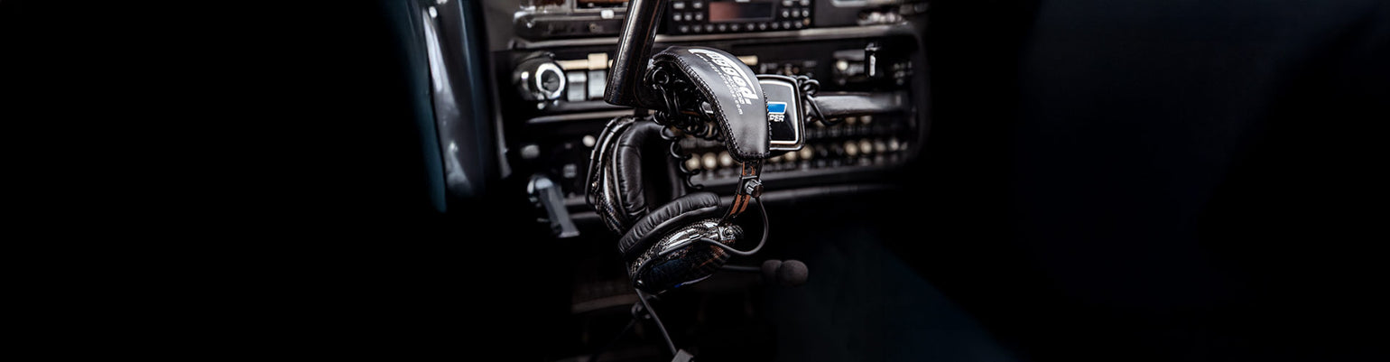 General aviation pilot headsets with noise‑reducing ear cups, boom mic, Bluetooth/ANR options, and carrying bag